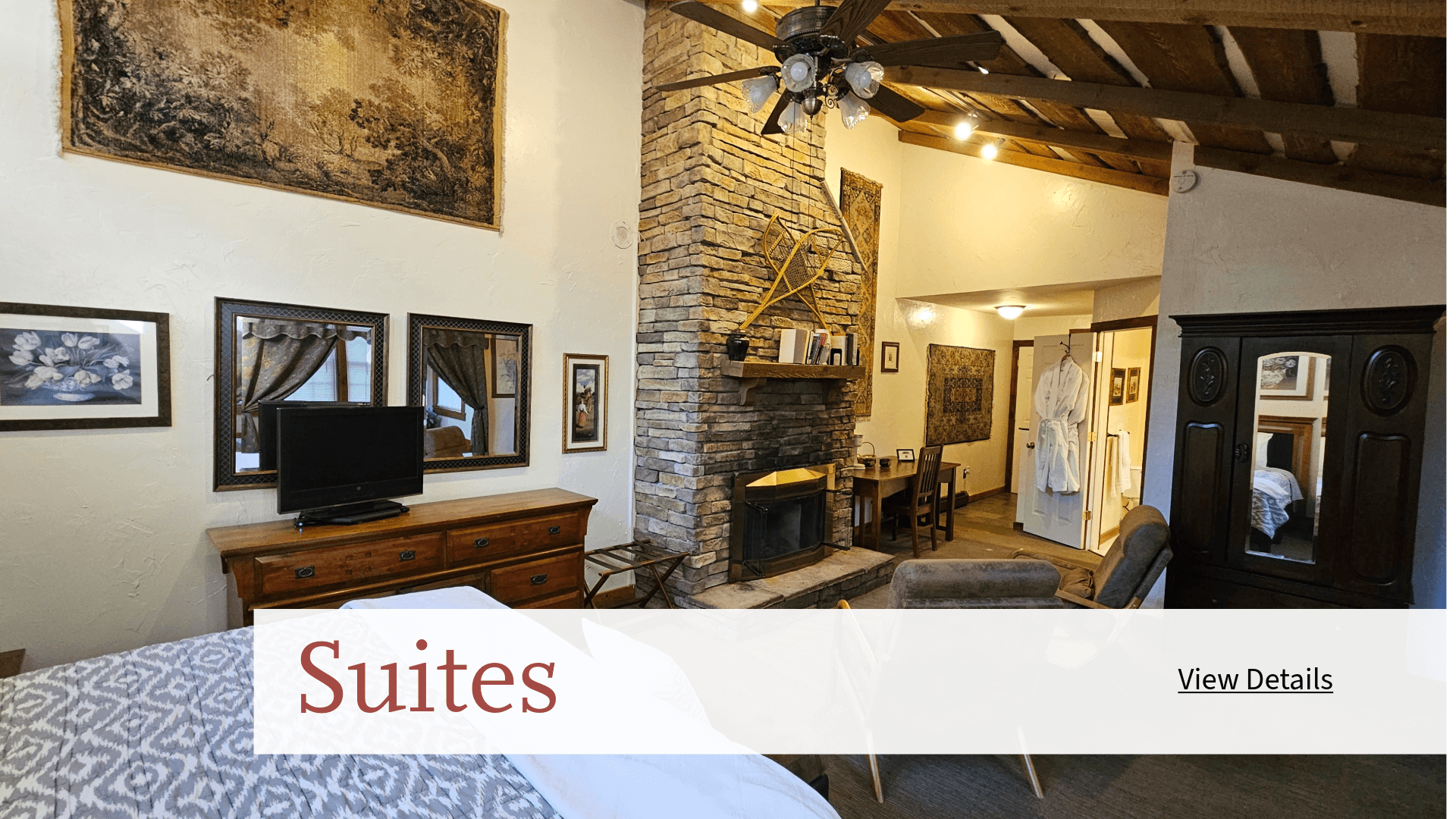 Cozy suite featuring a stone fireplace, seating area, and rustic decor.