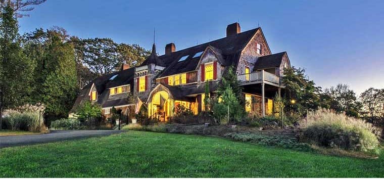 A large, elegant house surrounded by lush greenery at dusk. A large, elegant house surrounded by lush greenery at dusk.